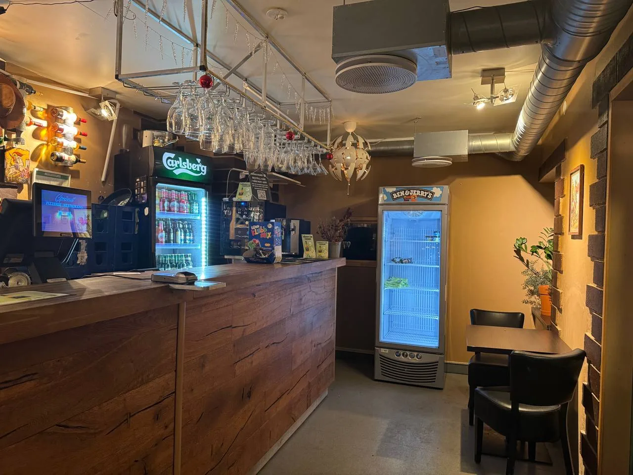 Baren på Gröna Huset med hängande glas över trädisken